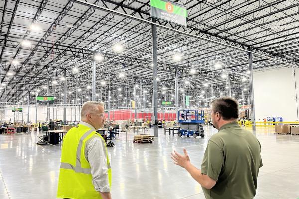 Eric Sorensen and local manufacturing worker look on at facility.