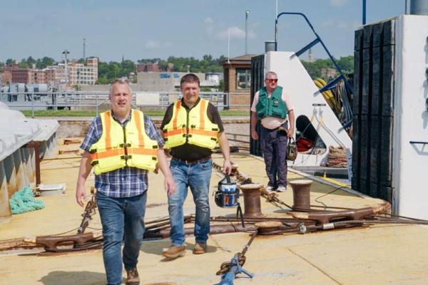 U.S. Rep. Eric Sorensen, D-Moline, (foreground) walks across a barge at Lock and Dam 15 in Rock Island as Rodney Knittel, Illinois Farm Bureau associate director of transportation and infrastructure, follows. (Photo by Scott Anderson)