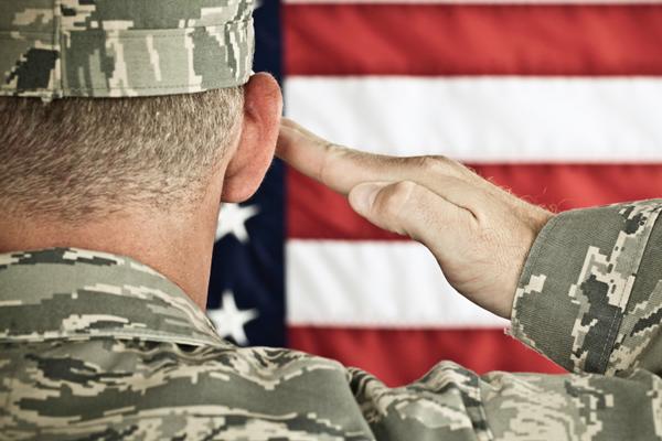 Military soldier saluting an American flag