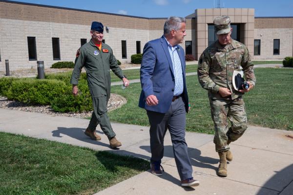 Representative Sorensen walking with two service members