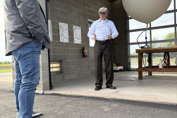Photo of Congressman Sorensen watching a weather balloon launch. 