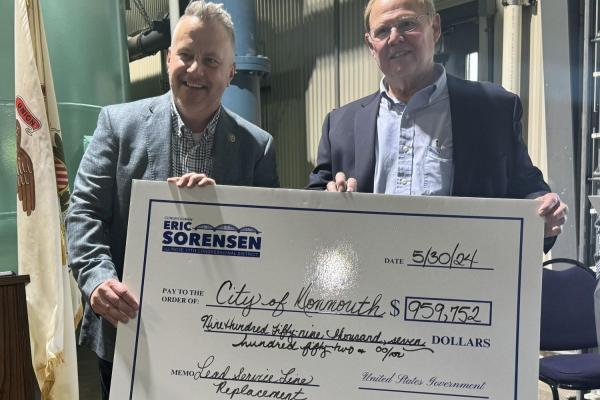 Rep Sorensen holds a check for the city of Monmouth