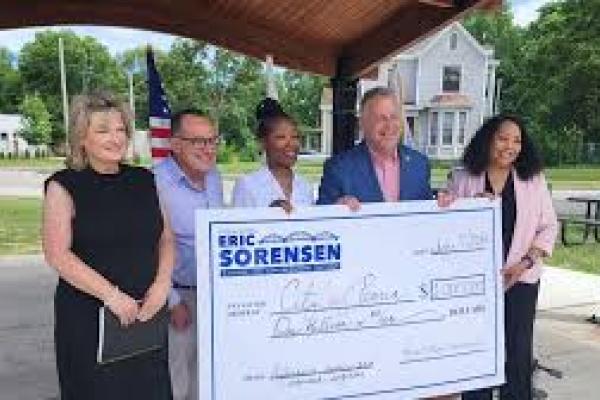 Rep sorensen holds a check of federal funds