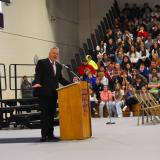 Congressman Eric Sorensen standing at a podium at Sherrard High School, speaking to a gym full of students.