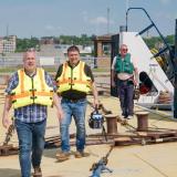 U.S. Rep. Eric Sorensen, D-Moline, (foreground) walks across a barge at Lock and Dam 15 in Rock Island as Rodney Knittel, Illinois Farm Bureau associate director of transportation and infrastructure, follows. (Photo by Scott Anderson)