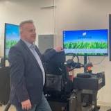 Rep. Sorensen stands with a farming simulator
