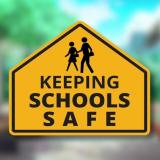 Sign reading "keeping schools safe"