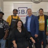 Representative Sorensen with owners of a local barber shop 