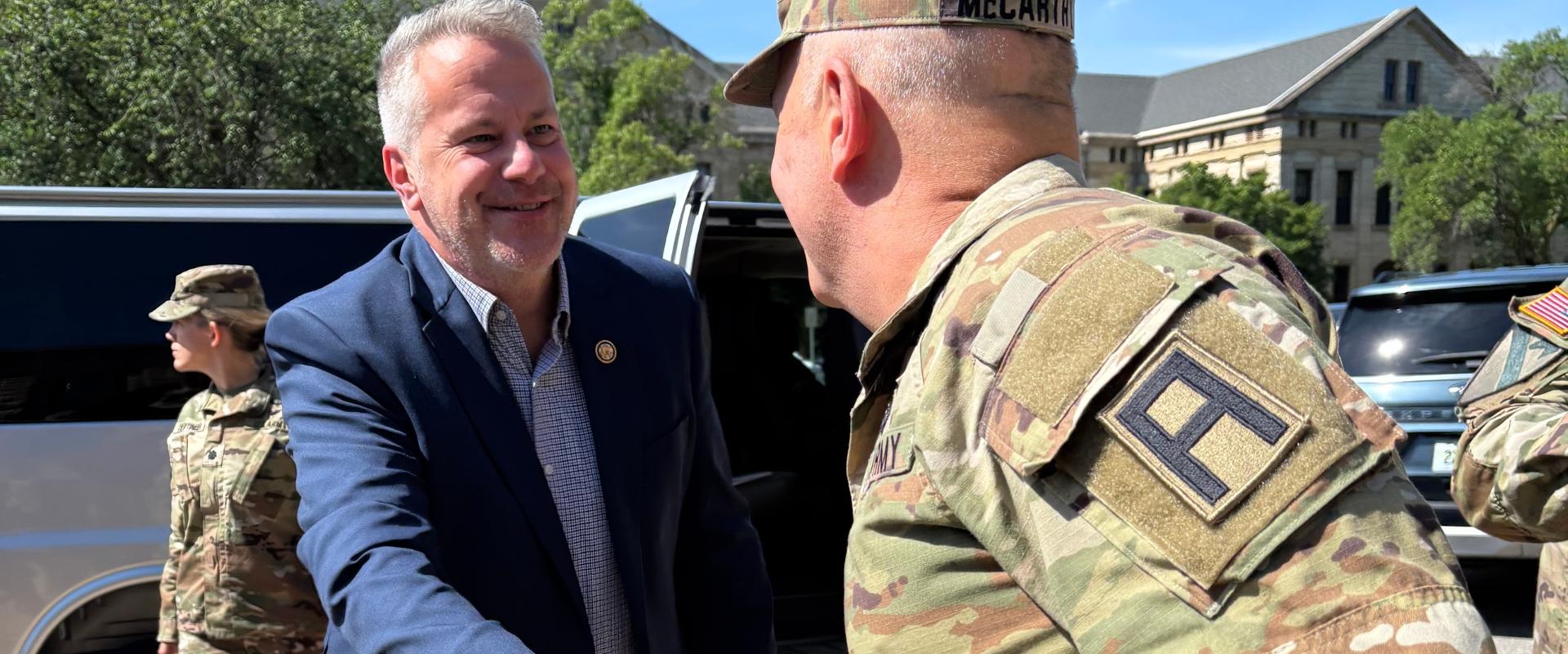 Congressman shakes hands with a U.S. servicemember at the Rock Island Arsenal