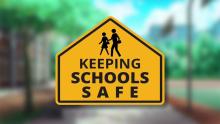 Sign reading "keeping schools safe"